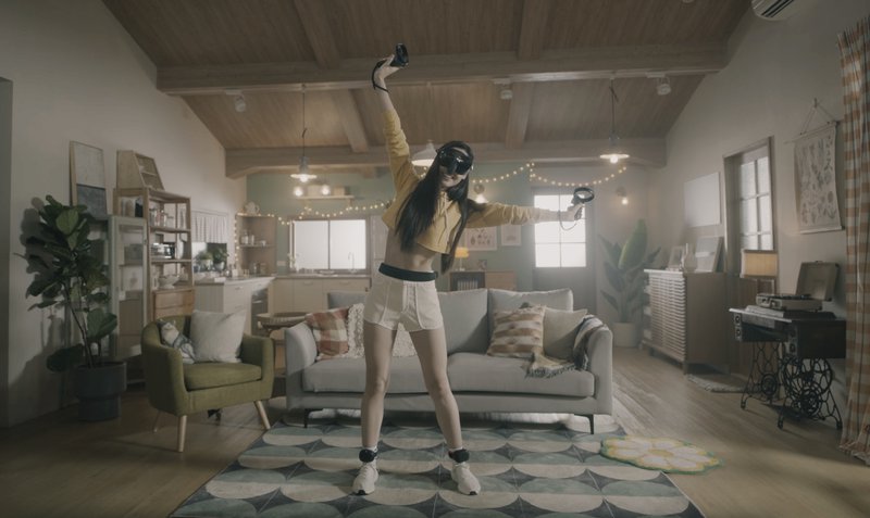 Woman with the VIVE XR Elite and VIVE Ultimate Trackers, the standalone VR headset and trackers from HTC VIVE, moving in a living room